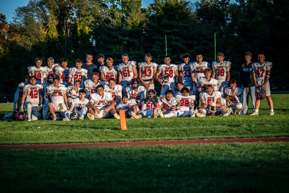 The Manalapan JV team together on the grass for a team photo at sunset.